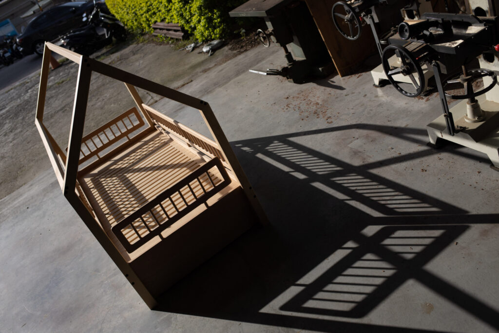 拾光小屋床俯拍，屋型框架的影子投在工房地面