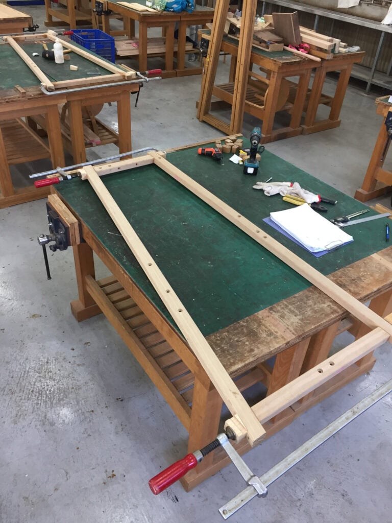 工房工作台上，一片新做的梯型框架上著夾具